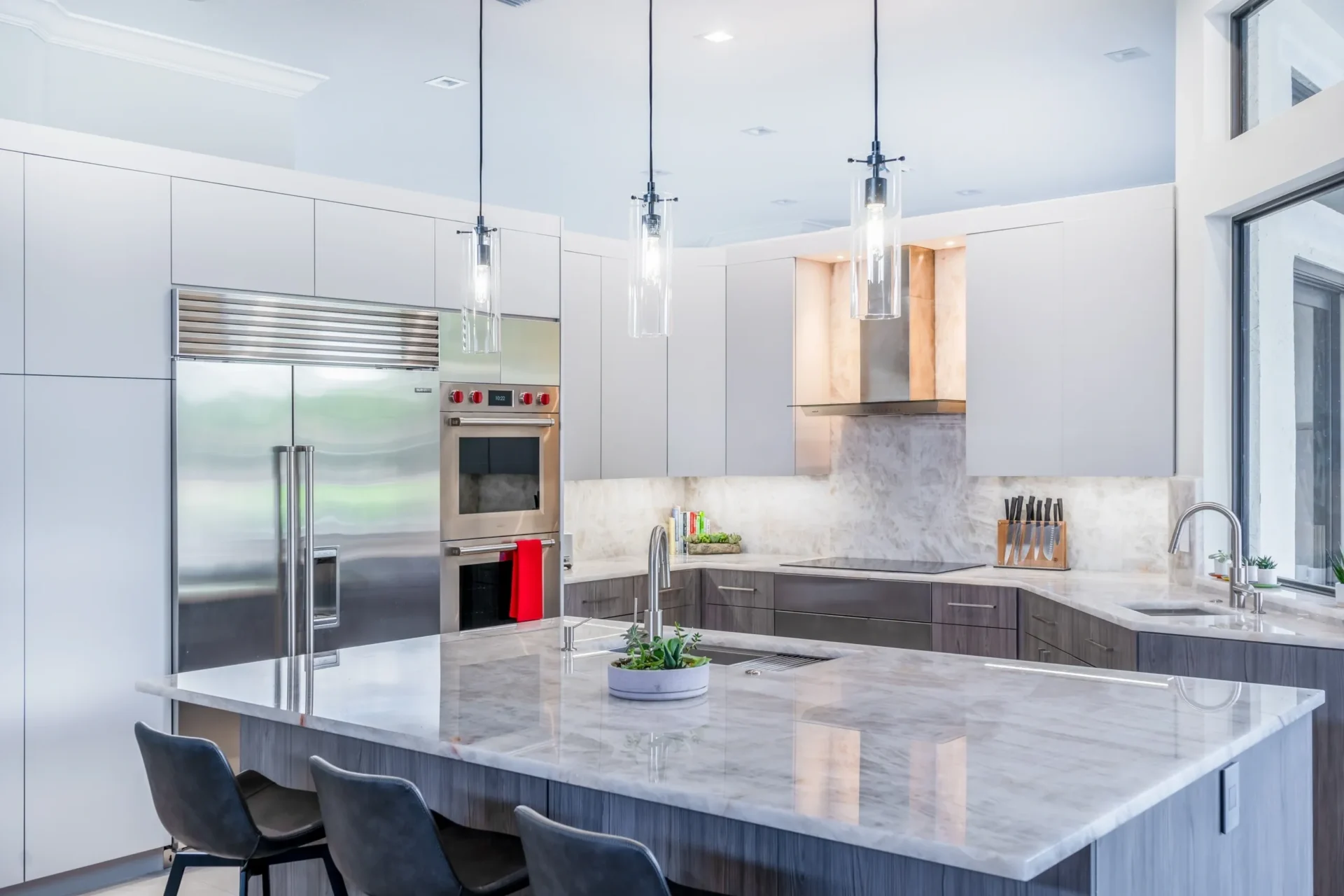 Modern kitchen with marble island and appliances.