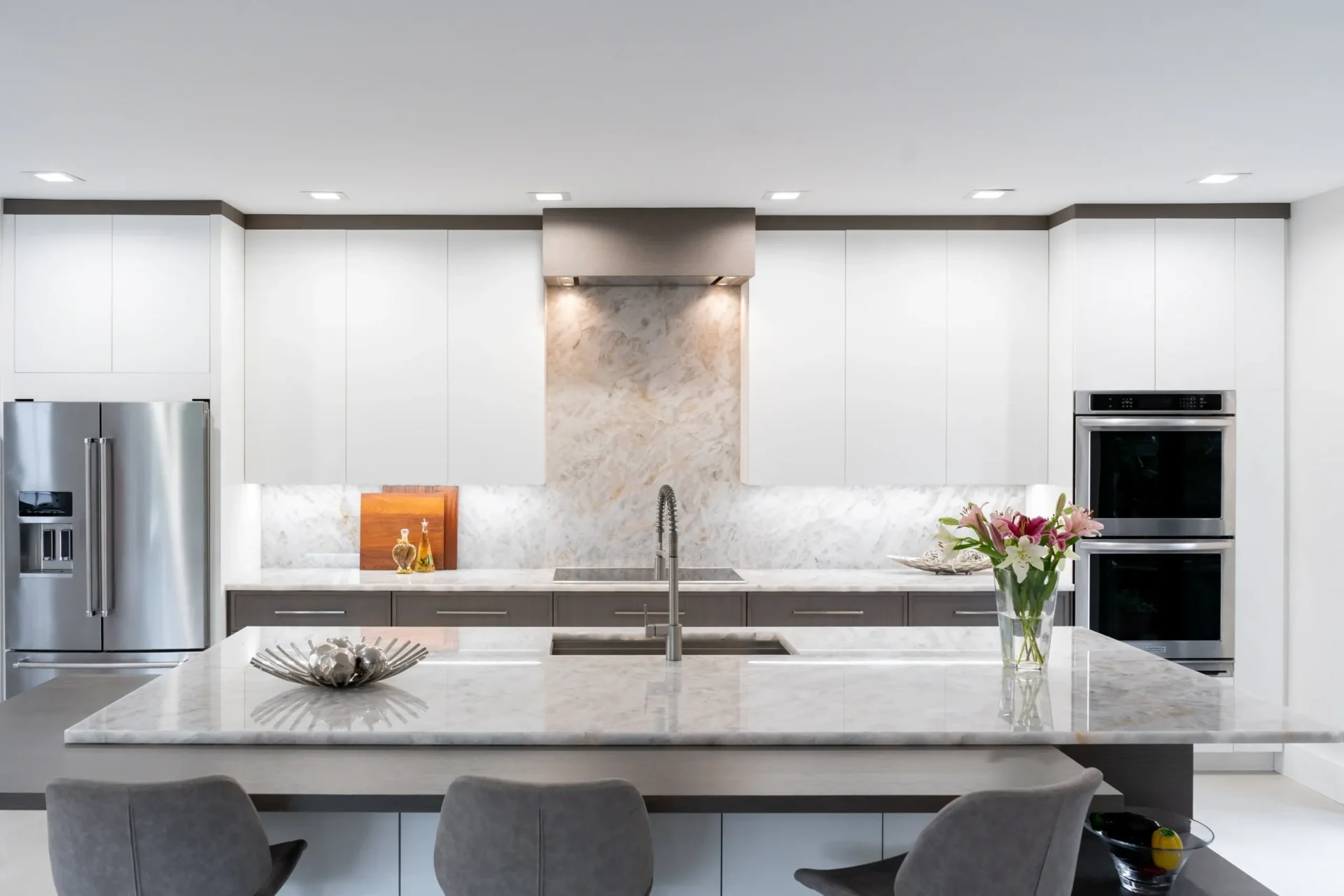 Modern kitchen with marble countertops and appliances.