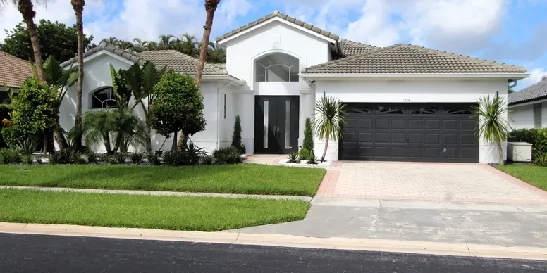 Modern white house with landscaped front yard.