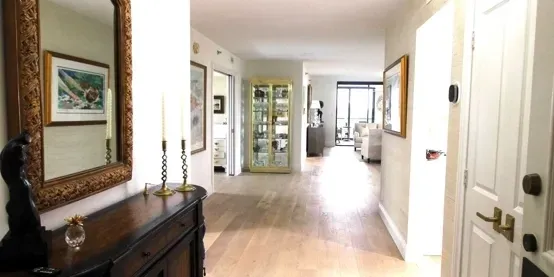 Spacious hallway with wooden floor and decor.