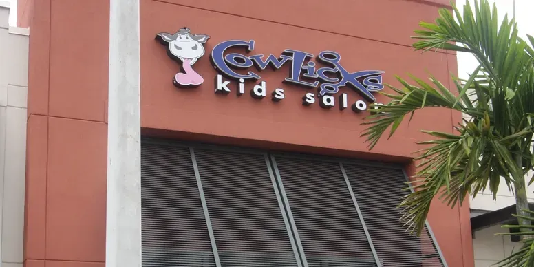 Kids salon storefront with cow logo.