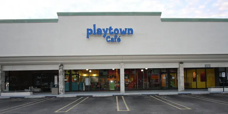 Playtown Café storefront with empty parking lot.