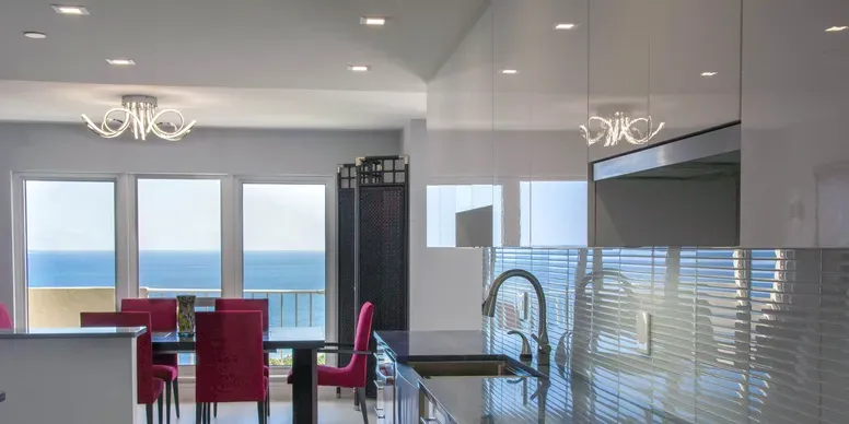Modern kitchen and dining area with ocean view.