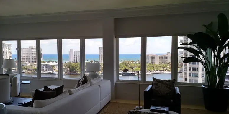 Living room with ocean view and plants.