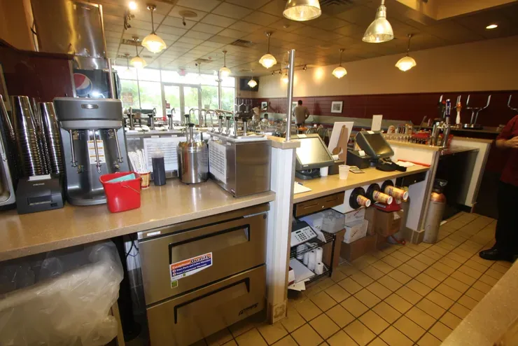 Restaurant counter with beverage machines and registers.